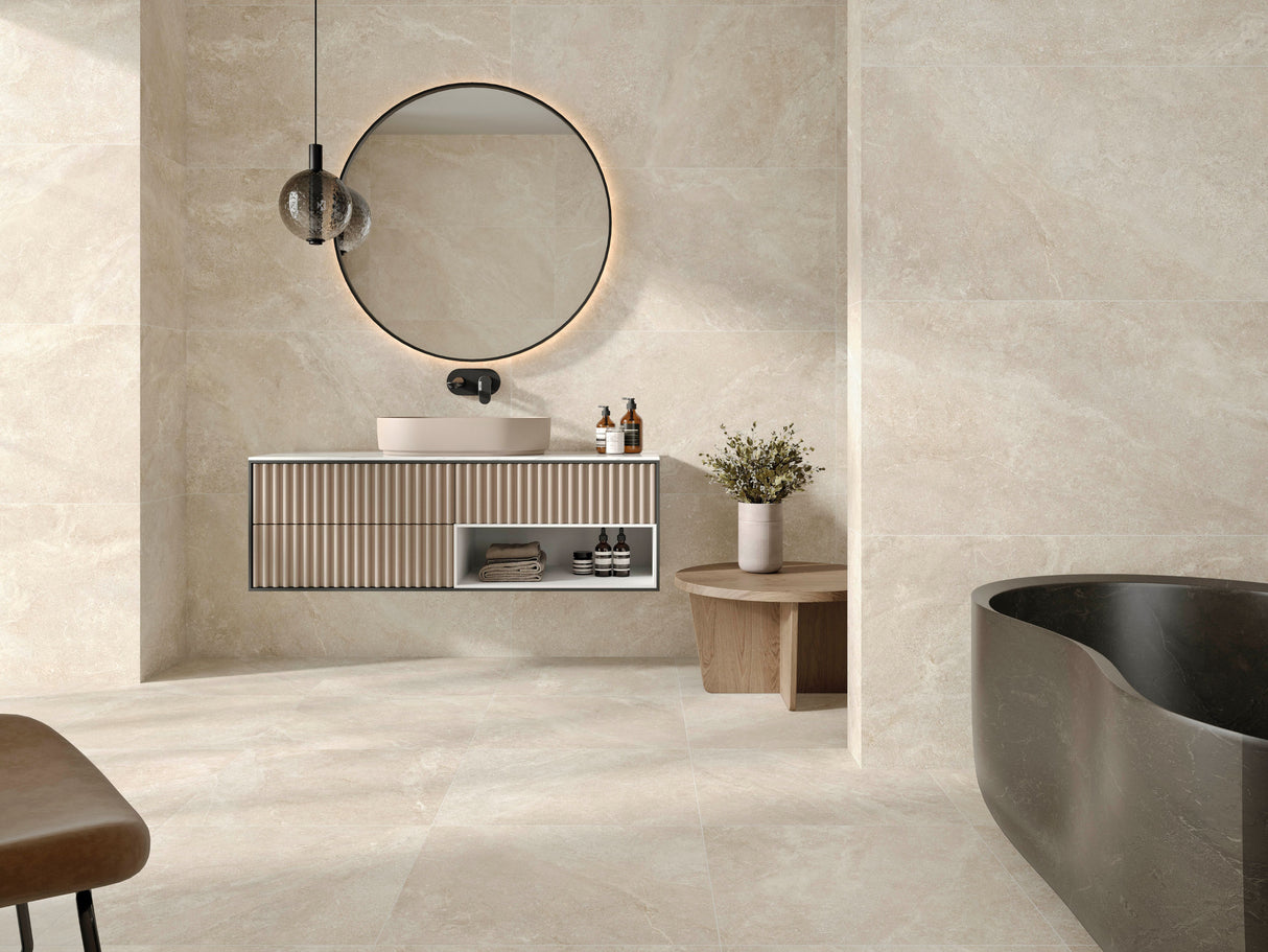 Modern bathroom with a vanity, round mirror, and freestanding bathtub on matte porcelain tile floor.