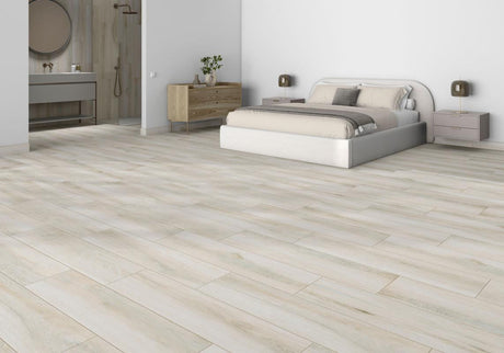 Contemporary bedroom with light oak wood-look plank flooring, platform bed, and ensuite bath visible