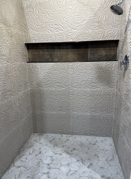 Walk-in shower with Calacatta hex mosaic tile floor and textured wall tile — small mosaic pieces follow the pan slope