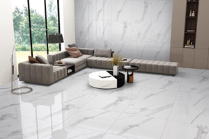 Modern living room with a gray sectional sofa, white coffee table, and porcelain tile floor and walls.