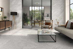 Modern living room with Spanish porcelain gray tiles, a glass coffee table, and a sofa.