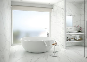 Modern bathroom with a freestanding bathtub and a white ceramic tile feature wall that looks like subway tiles.