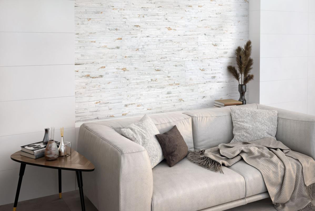 Gray sofa with decorative pillows and blankets in a room with a Thuy Blanco 3D Textured Ledger Look Porcelain Wall Tile