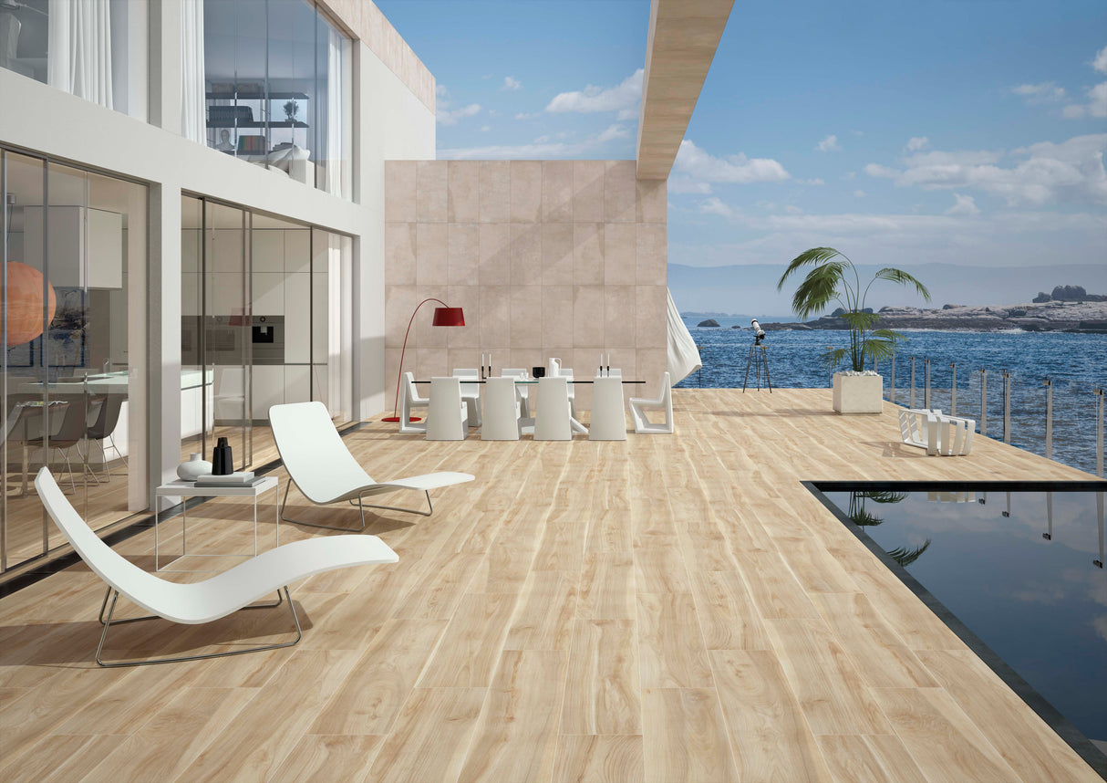 Spanish wood-look floor tiles installed on a modern outdoor terrace with white lounge chairs, a dining set, a pool, and a ocean view background.